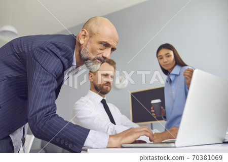 Group of business partners looking at laptop screen for presentation of new project Group of business partners looking at laptop screen for presentation of new project 70381069