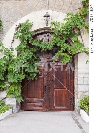 Old rural house wall with dark wooden door 70381624