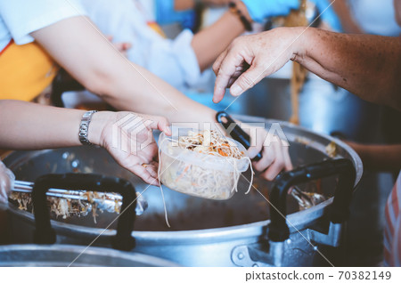 Volunteers serving food for poor people Volunteers serving food for poor people 70382149