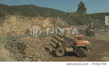 The lorry is pouring stones out. The lorry is pouring stones out. 70382708