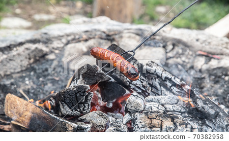 Sausage roasted over an almost extinguished fire Sausage roasted over an almost extinguished fire 70382958