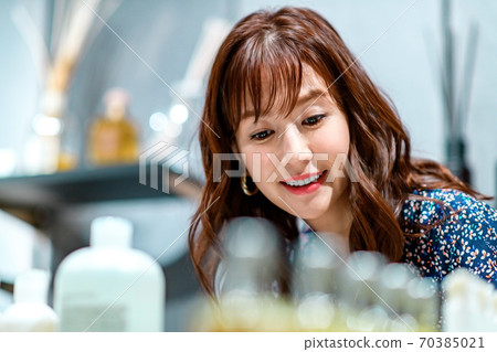 在購物時仔細檢查產品的年輕女性 在購物時仔細檢查產品的年輕女性 70385021
