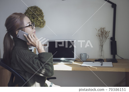 婦女和書桌用品在家庭辦公室中遠程工作 70386151