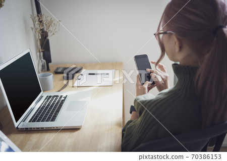 Women and desk supplies working remotely in their home office Women and desk supplies working remotely in their home office 70386153