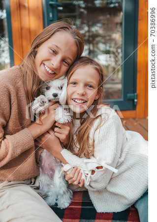 Happy kids sitting on the terrace of their house in autumn 70386996