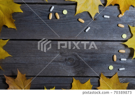 .Autumn foliage and medicines on wooden background 70389873