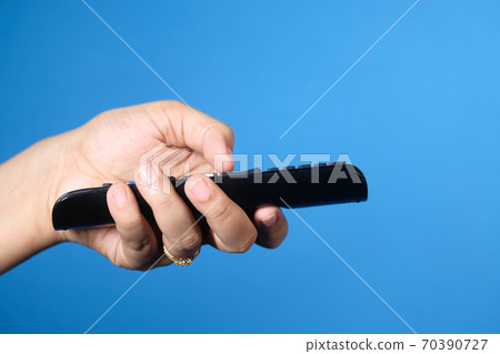 close up of women hand holding tv remote. 70390727