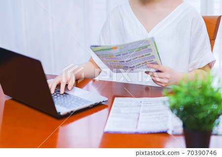 年輕女子一邊看小冊子一邊安排旅行[去旅行運動] 70390746