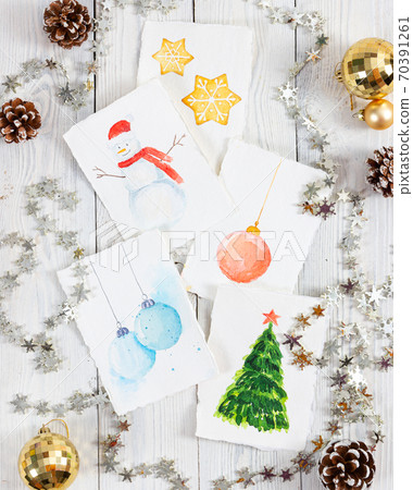 Workplace of the artist with christmas pictures on light wooden background. 70391261