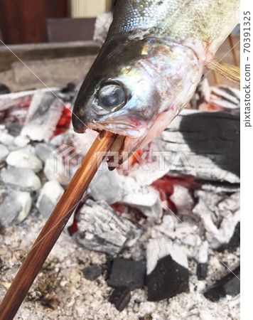 Bake river fish over charcoal 70391325