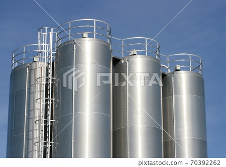 View of an industrial plant with large aluminum tanks 70392262