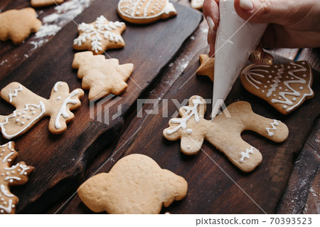 Decorating gingerbread cookie with sugar icing 70393523