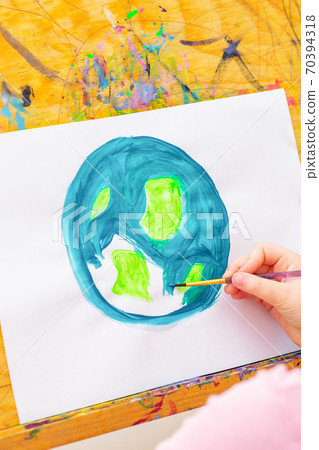 Little girl is drawing earth. 70394318
