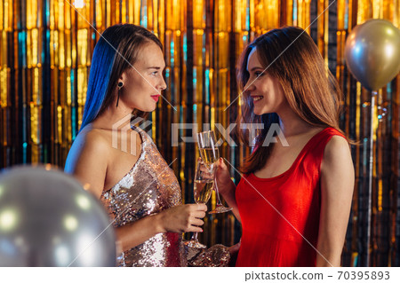 Two girls toasting celebrating New Year or Christmas Two girls toasting celebrating New Year or Christmas 70395893