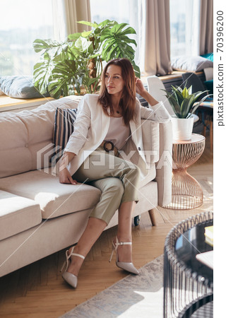 Portrait of young woman relaxing on couch at home. 70396200