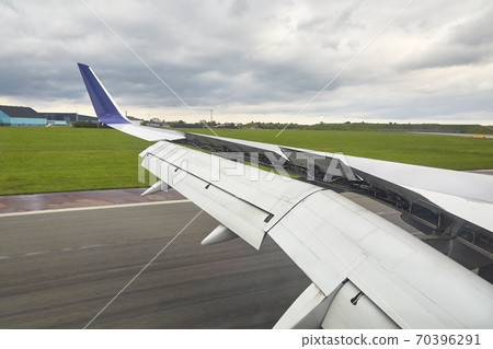 Landing plane wing flaps and spoilers extended Landing plane wing flaps and spoilers extended 70396291