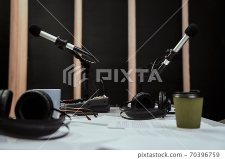 Working place of radio host. Close up of microphones, headphones and sound mixing desk on the table in recording studio or broadcast room Working place of radio host. Close up of microphones, headphones and sound mixing desk on the table in recording studio or broadcast room 70396759
