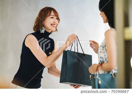 Female clerk handing over the product 70398667