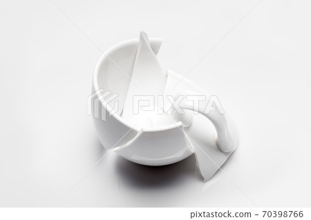 broken white ceramic tea cup on a white background, conceptual photo with a shattered object. 70398766