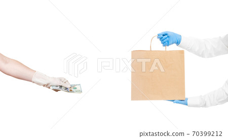 faceless delivery man hold in hands brown craft paper package and hand holds give money to pay for food delivery isolated on white, safe online buy social distance, stay home. faceless delivery man hold in hands brown craft paper package and hand holds give money to pay for food delivery isolated on white, safe online buy social distance, stay home. 70399212