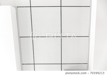 multi-level ceiling with three-dimensional protrusions and a suspended tiled ceiling white color, close up geometric empty details, top view. multi-level ceiling with three-dimensional protrusions and a suspended tiled ceiling white color, close up geometric empty details, top view. 70399213