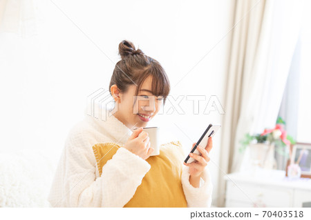 Woman holding a smartphone Woman holding a smartphone 70403518