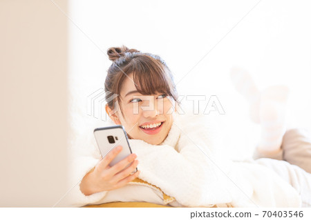 A woman watching a smartphone A woman watching a smartphone 70403546
