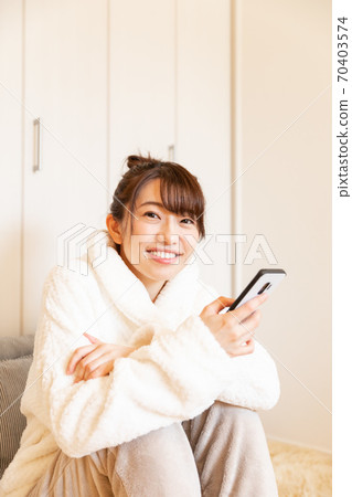 Woman holding a smartphone Woman holding a smartphone 70403574