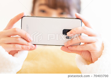 Woman holding a smartphone Woman holding a smartphone 70403700