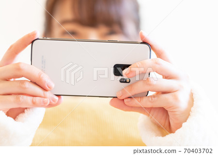 Woman holding a smartphone Woman holding a smartphone 70403702