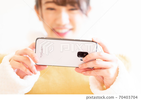Woman holding a smartphone Woman holding a smartphone 70403704