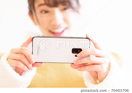 Woman holding a smartphone Woman holding a smartphone 70403706