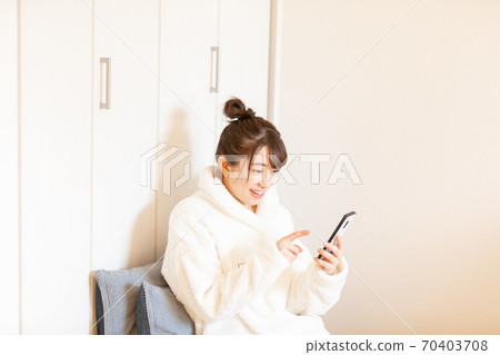 Woman holding a smartphone Woman holding a smartphone 70403708