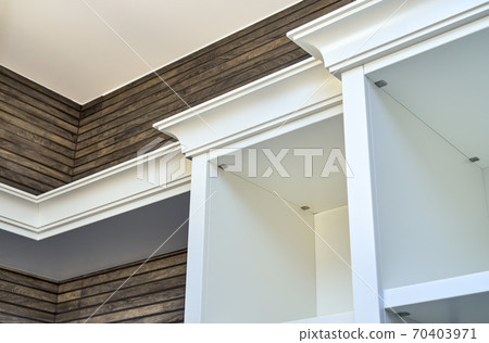 White wooden cabinet crown molding on wooden slats wall background White wooden cabinet crown molding on wooden slats wall background 70403971