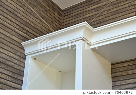 White wooden cabinet crown molding on wooden slats wall background White wooden cabinet crown molding on wooden slats wall background 70403972