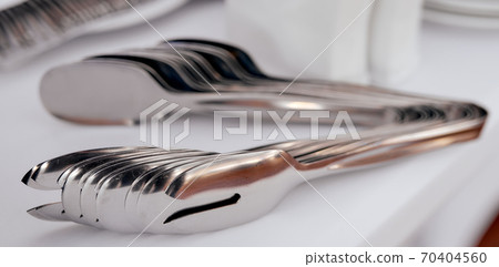 many food tongs on white table in each other many food tongs on white table in each other 70404560