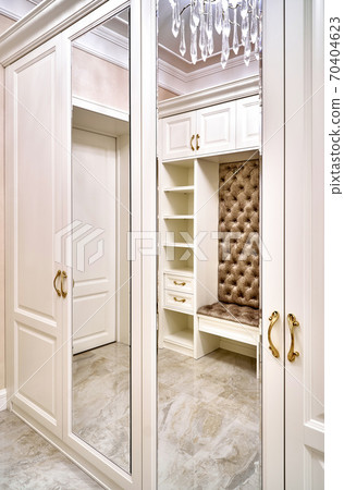 Classic white wardrobe with mirror doors in contemporary bright hallway. Carriage coupler closet bench Classic white wardrobe with mirror doors in contemporary bright hallway. Carriage coupler closet bench 70404623