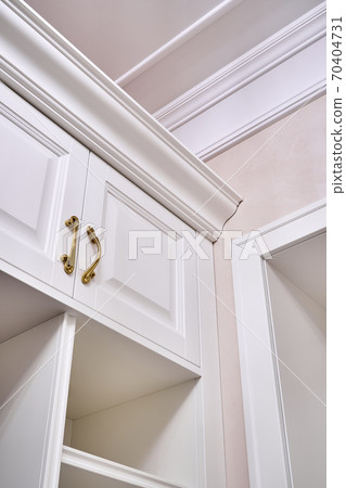 Classic white wardrobe with shelves in contemporary bright hallway Classic white wardrobe with shelves in contemporary bright hallway 70404731