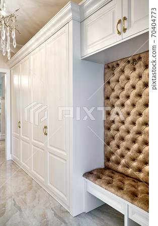 Classic white wardrobe with seating in contemporary bright hallway. Carriage coupler closet bench Classic white wardrobe with seating in contemporary bright hallway. Carriage coupler closet bench 70404773