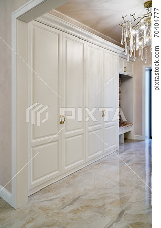 Classic white wardrobe with seating in contemporary bright hallway. Carriage coupler closet bench Classic white wardrobe with seating in contemporary bright hallway. Carriage coupler closet bench 70404777