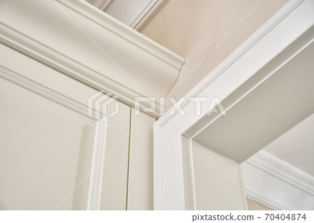 Detail of classic white wardrobe in contemporary bright hallway Detail of classic white wardrobe in contemporary bright hallway 70404874