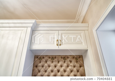 Classic white wardrobe with seating in contemporary bright hallway. Carriage coupler closet bench 70404881