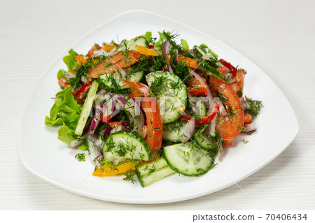 rustic salad of fresh cucumbers, tomatoes and onions, decorated with greens, on plate rustic salad of fresh cucumbers, tomatoes and onions, decorated with greens, on plate 70406434