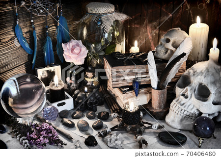 Mysterious still life with runes, evil skull and spell book on witch table.  Esoteric, gothic and occult background with magic objects. Halloween fortune telling concept. 70406480