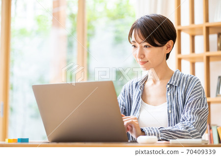 在客廳裡的中年女子遠程辦公 70409339