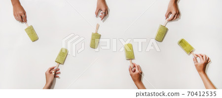 Womens hands taking green matcha coconut 70412535