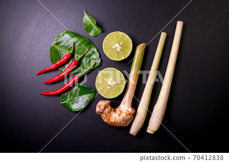 Mix ingredients of tom yum goong on black table, composed of lime, red chili, kaffir lime leaf, lemongrass, galangal.Food top view. Mix ingredients of tom yum goong on black table, composed of lime, red chili, kaffir lime leaf, lemongrass, galangal.Food top view. 70412838