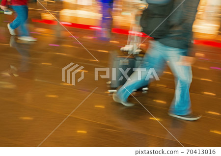 people tourists with travel suitcase luggage in blurred speed motion 70413016