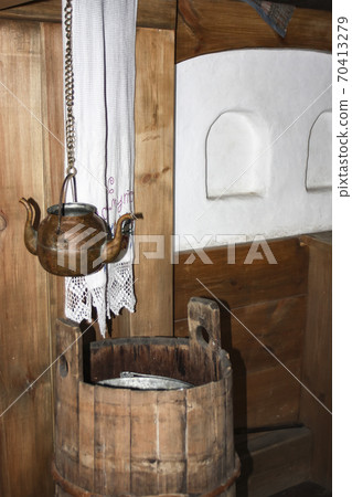 Copper vessel for drinking water (kettle with two spouts) in the interior of a traditional wooden house 70413279