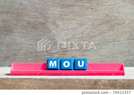 Tile letter on red rack in word MOU (Abbreviation of memorandum of understanding) on wood background Tile letter on red rack in word MOU (Abbreviation of memorandum of understanding) on wood background 70413357